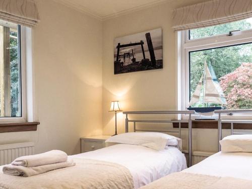 a bedroom with two beds and a sailboat in the window at Tigh-na-creige in Feorlean