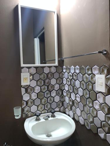 a bathroom with a sink and a mirror at Departamento Dulce mania 2 in Carhué