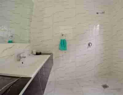 Baño blanco con lavabo y espejo en Tauhara Luxury Apartment en Okaihau
