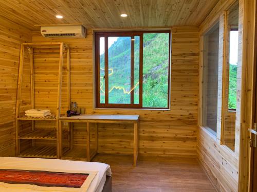 a wooden room with two beds and a window at Meo Vac Valley in Mèo Vạc