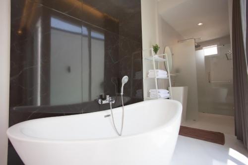 a white bath tub in a bathroom with a shower at KVILLA in Ban Khlong Bang Chak
