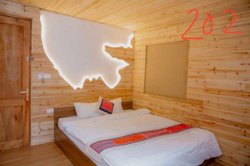 a bedroom with a bed in a wooden room at Meo Vac Valley in Mèo Vạc