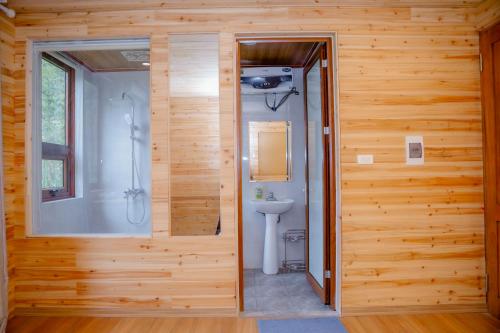 a wooden bathroom with a shower and a toilet at Meo Vac Valley in Mèo Vạc