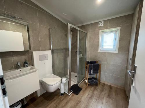 uma casa de banho com um WC e um chuveiro em Holiday home island view in Nowe Warpno em Nowe Warpno