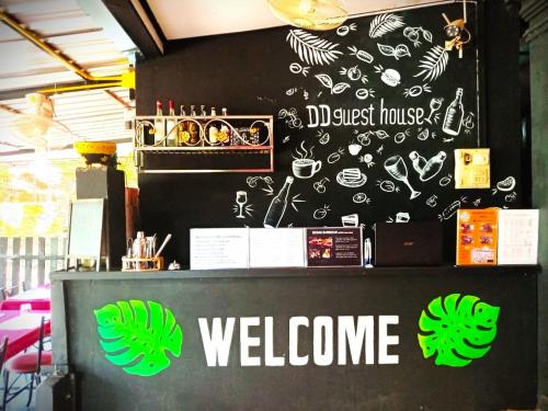 a black wall with a welcome sign on it at Dee-Dee's Guest House, Bed And Breakfast in Pakse