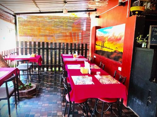 a restaurant with red tables and chairs in a room at DD Guest House in Pakse