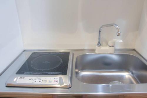a kitchen counter with a sink next to a sink at Fortune house 步行直達大阪京瓷巨蛋 直達梅田 桜川4丁目 in Osaka