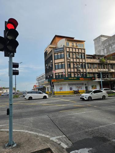 a traffic light at an intersection with cars on a street at AeCOTEL in Sandakan