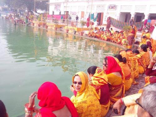 eine Gruppe von Frauen, die um einen Wasserkörper herum sitzen in der Unterkunft Mithila Culture Homestay Janak Kuti in Janakpur