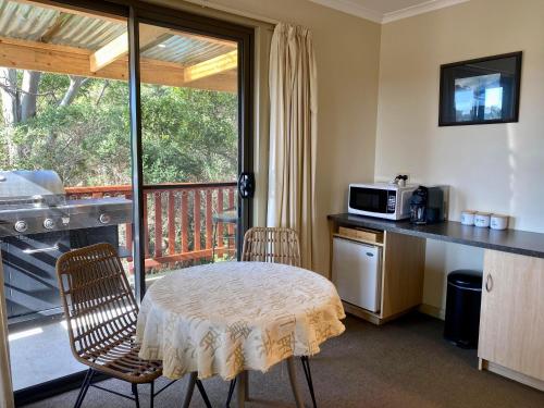 een keuken met een tafel en stoelen en een balkon bij Gordon Gateway in Strahan