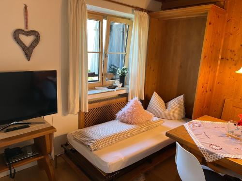 a small room with a bed and a window at Ferienhaus Heimhof in Garmisch-Partenkirchen