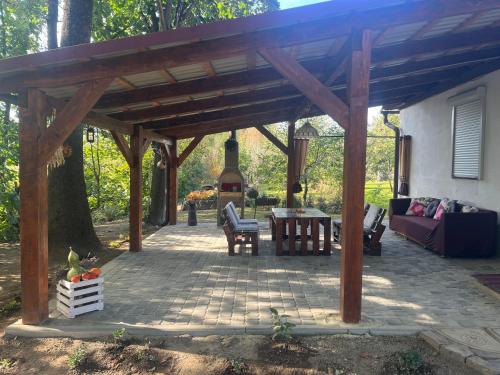 a patio with a wooden pergola and a couch at Hotel Окремий Будинок-Апартаменти in Rakoshyno