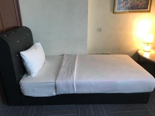 Bett in einem Hotelzimmer mit einem weißen Kissen in der Unterkunft AmyliaLee service suit berjaya time square at kl in Kuala Lumpur