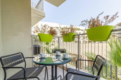 d'une terrasse avec une table et des chaises sur un balcon. dans l'établissement Jaffa's Hideaway - Lux 2BR w/balcony and parking!, à Tel Aviv