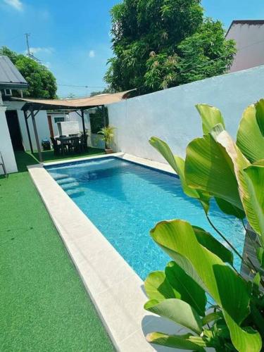 Sönmez Private Villa في Cavite: حمام سباحة عشب أخضر و منزل