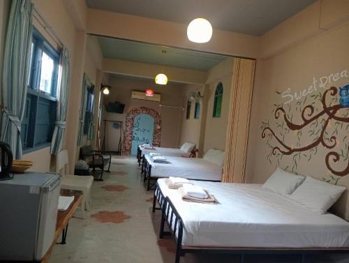 eine Reihe von 4 Betten in einem Zimmer in der Unterkunft Chanchaolao Beach Resort in Chao Lao Beach