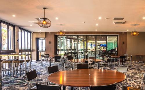 a dining room with tables and chairs and windows at Ceduna Foreshore Hotel Motel in Ceduna