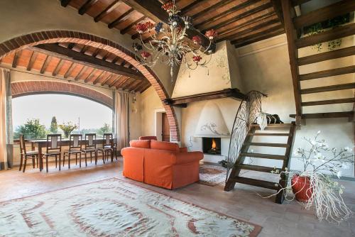 un soggiorno con scala, divano e camino di Il Casale Del Marchese a Bettolle