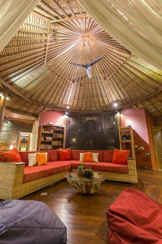 un soggiorno con divano e un grande soffitto di Villa Pilou Boutique Hotel a Tanah Lot