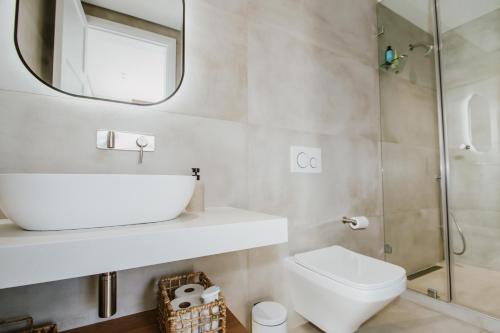 a bathroom with a sink and a toilet and a mirror at Quiet Hideaway in Somerset West