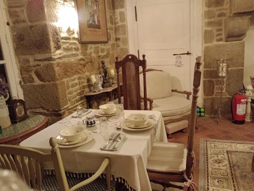a dining room with a white table and chairs at Le Presbytere in Beauficel
