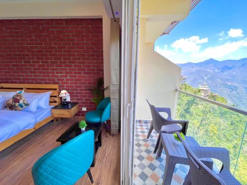 Habitación con balcón con 1 cama y sillas. en Hotel Pinerock & Cafe, Mussoorie - Mountain View Luxury Rooms with open Rooftop Cafe en Mussoorie