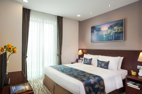 a hotel room with a large bed and a large window at Somerset Central TD Hai Phong City in Hai Phong