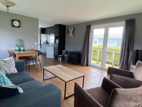 een woonkamer met een bank en een tafel bij Chalet with 2 bedrooms for 4 people for rent in Hoorn Netherlands in Hoorn