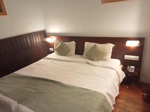 a large bed with white sheets and pillows at La Gabriell beach inn in Calangute