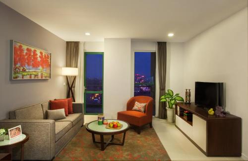 a living room with a couch and a tv at Somerset Central TD Hai Phong City in Hai Phong