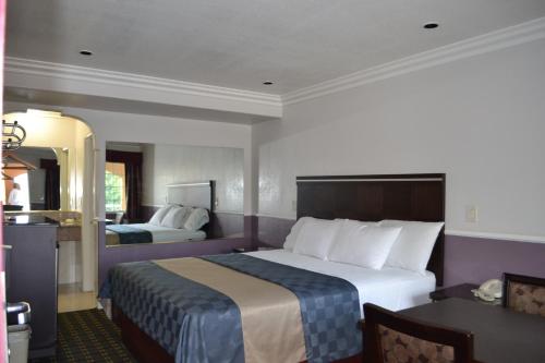 Habitación de hotel con cama grande y espejo en Galaxy Inn, en Los Ángeles
