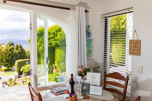 a dining room with a table and a large window at Million Dollar Views in Hobart