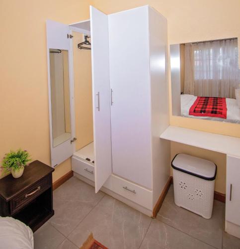 a small room with a bed and a mirror at Ebony Mara - Green House in Narok
