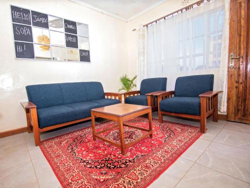 a waiting room with two blue chairs and a table at Ebony Mara - Green House in Narok