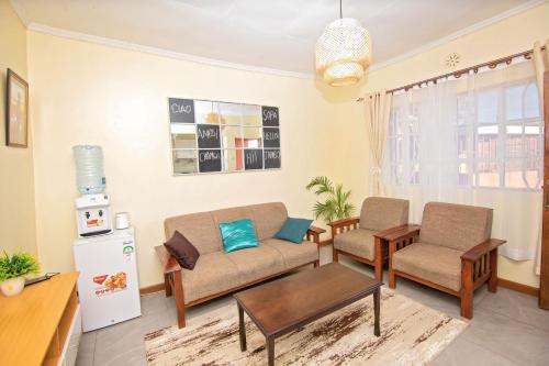 un soggiorno con divano e 2 sedie di Ebony Mara a Narok