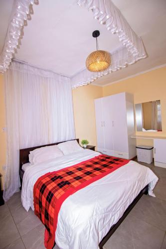 a bedroom with a bed with a red and black blanket at Ebony Mara - Green House in Narok