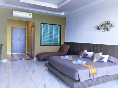 um quarto com uma cama e uma cadeira em The Wynn Kohjum em Ko Jum