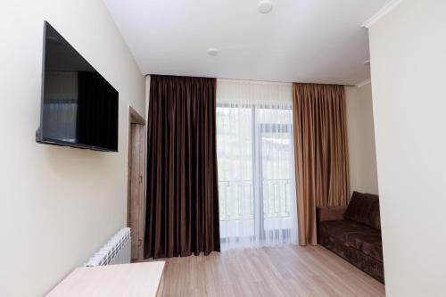 a living room with a couch and a flat screen tv at Dream Hotel in Haghpat