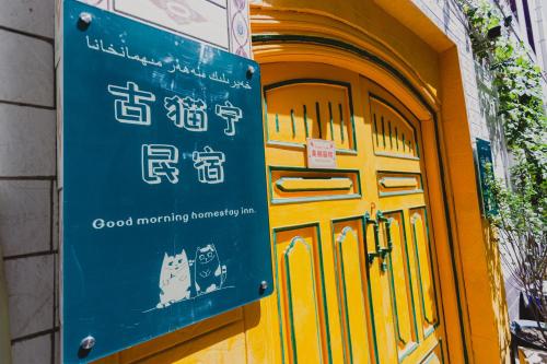 a sign in front of a door with a cat on it at Good Morning International Chain Hostel Of Kashgar City in Kashgar