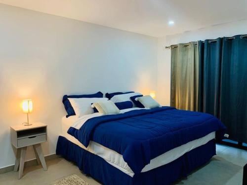 a bedroom with a large bed with a blue blanket at Second Home in San Salvador