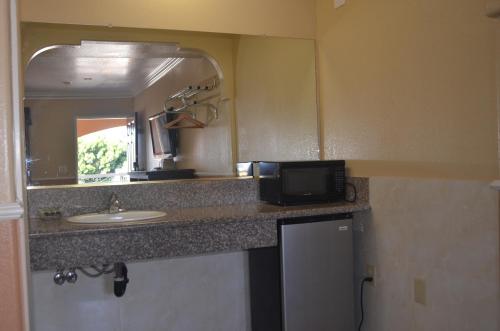 a bathroom with a sink and a mirror at Galaxy Inn in Los Angeles