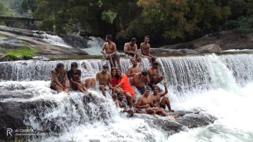 a group of people sitting on top of a waterfall at Abimansala Resort in Hunnasgiriya