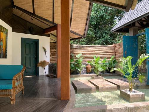 a porch with a blue door and a chair at Villa Amuntai with Pool & Jacuzzi in Dinalupihan