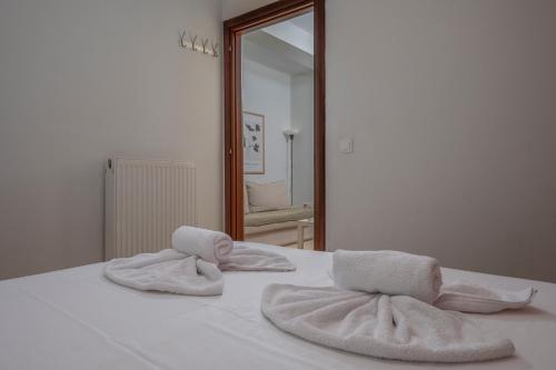 een bed met handdoeken en een spiegel bij Sigrou 44 in Thessaloniki