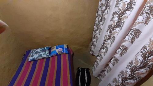 a curtain next to a bed with apron and a curtainngth at Abimansala Resort in Hunnasgiriya