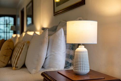 a lamp on a table next to a couch with pillows at Million Dollar Views in Hobart