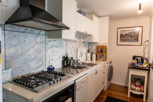 a kitchen with a stove and a sink at Million Dollar Views in Hobart