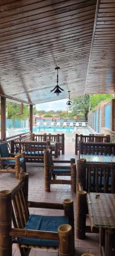 um restaurante com bancos e mesas de madeira e um tecto em Chateau Orberi em Ikalto