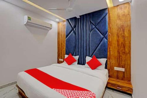 Un dormitorio con una cama con almohadas rojas. en HOTEL GK VILLA, en Ahmedabad