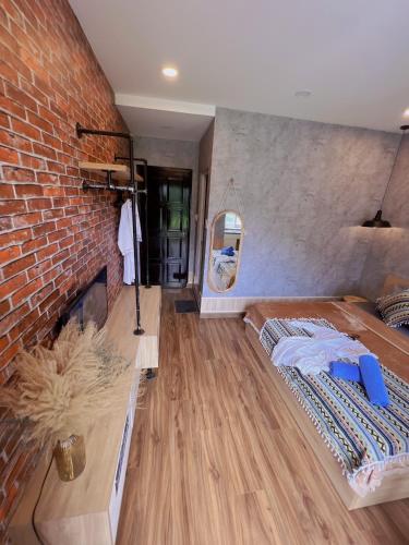 a room with a bed and a brick wall at MIS HOSTEL Cần Thơ in Can Tho